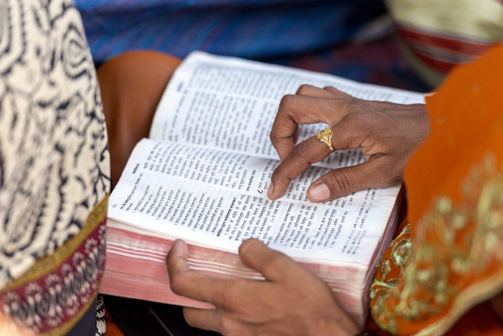 A South Asian woman reads a Bible.