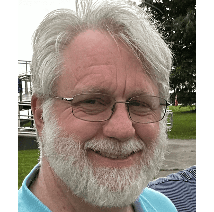 Smiling man with glasses outdoors, emphasizing relationships over resources.