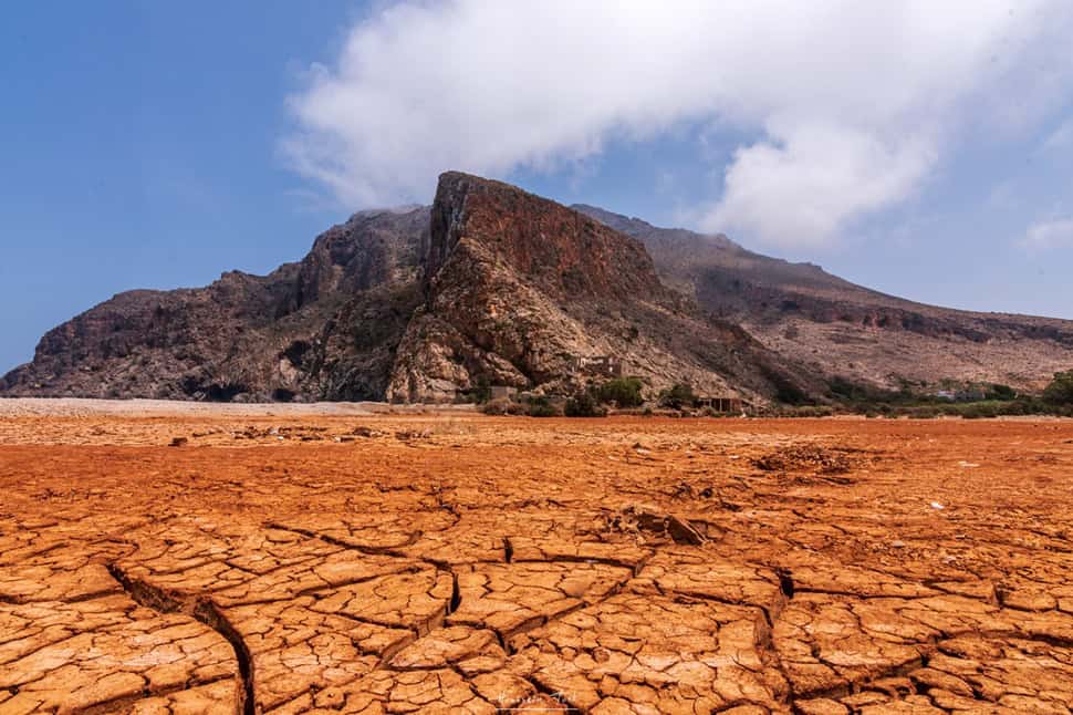 Healing the Wounds of Trauma - Arid landscape with cracked earth and mountain backdrop.