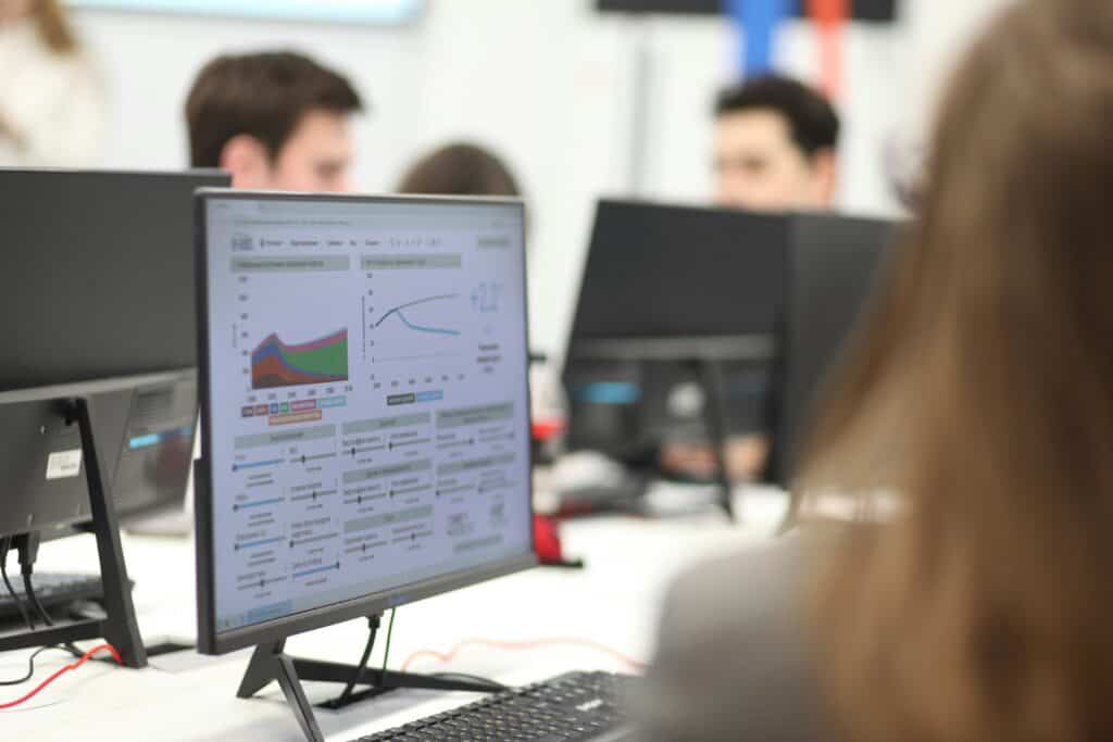 Mission agency team analyzing data on a computer screen for metrics dashboard.