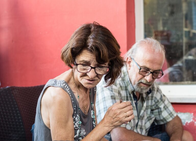 Elderly couple sharing a moment outdoors, engaging in conversation.
