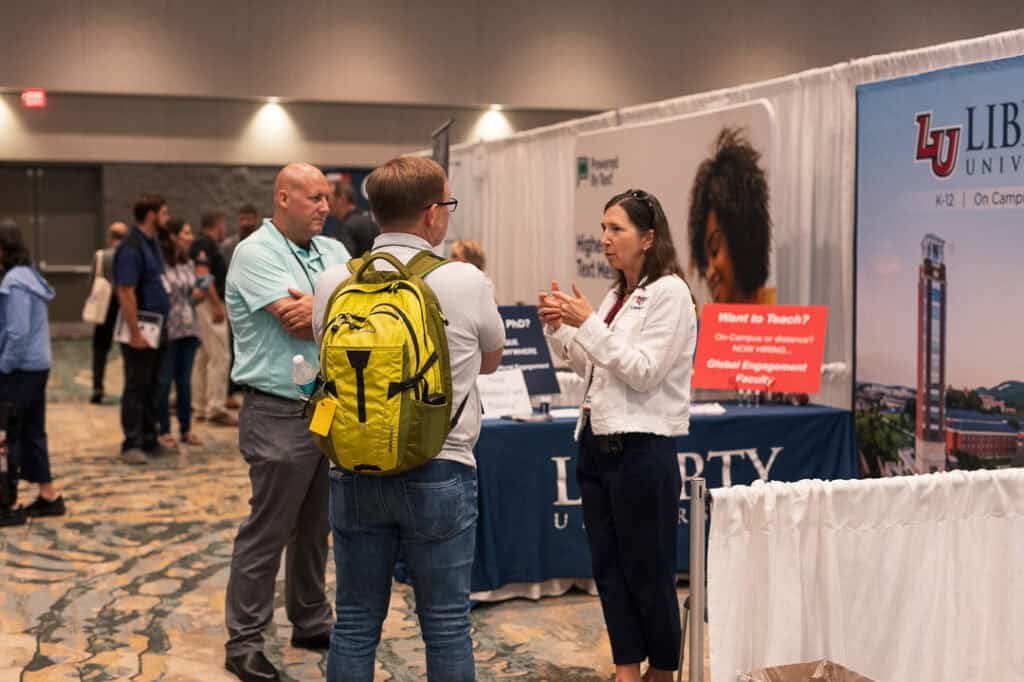 Attendees engaging in conversation at Missio Nexus conference booth.