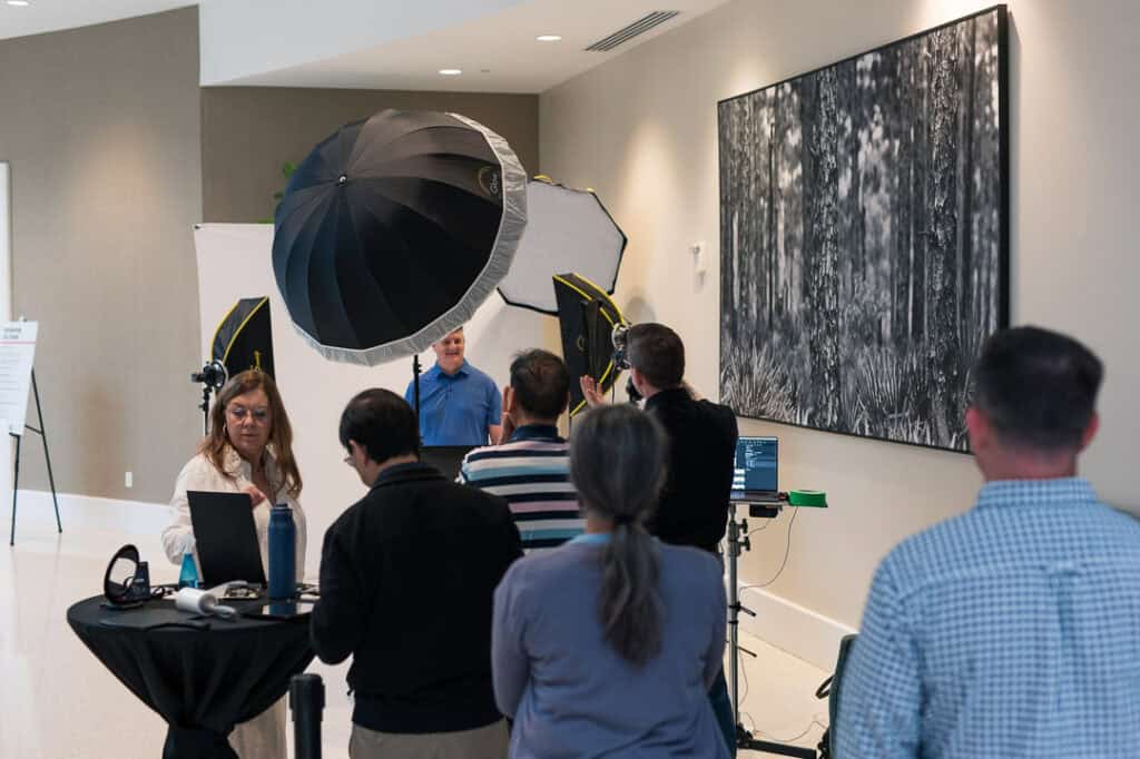Attendees at Missio Nexus conference with photography equipment and a large artwork.